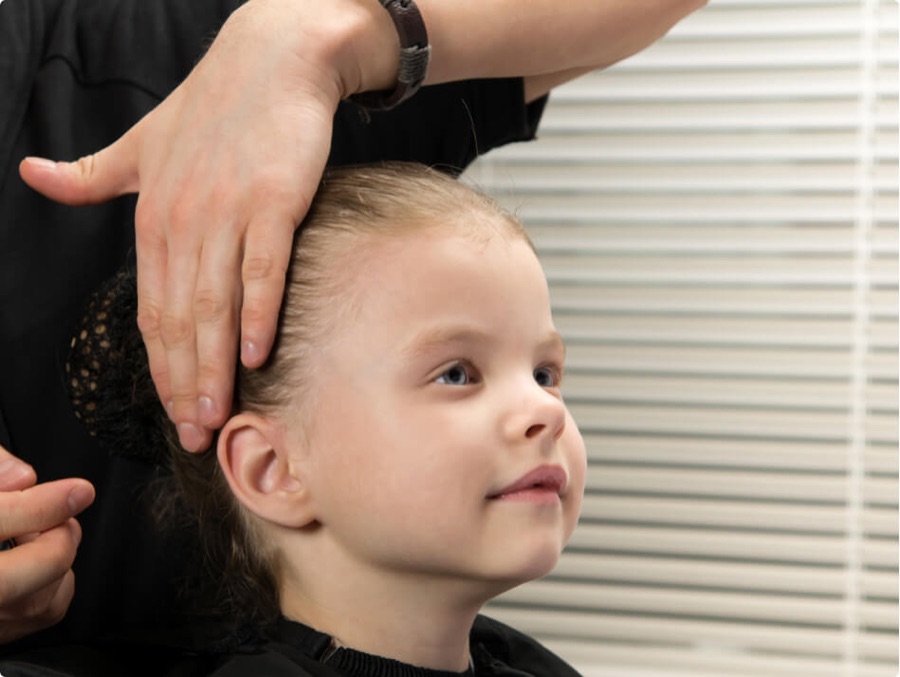 A child receiving a careful, professional head check at the lice treatment clinic